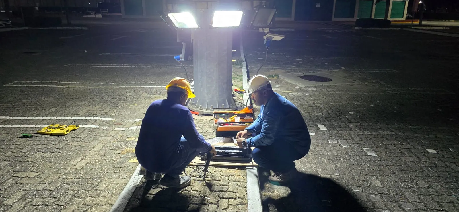 Equipe técnica em operação elétrica noturna
